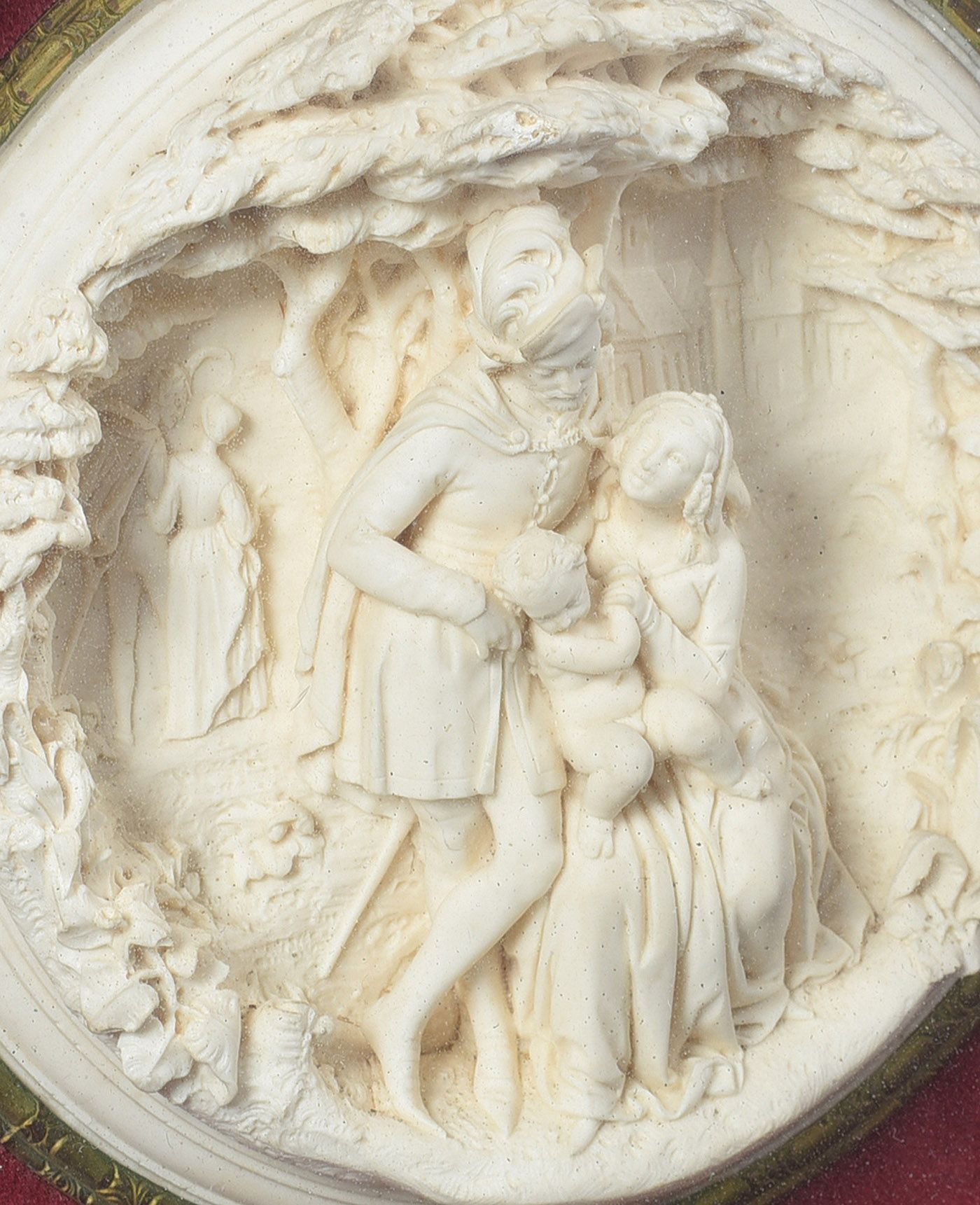 A VICTORIAN CIRCULAR CARVED BONE PICTURE OF A FAMILY GROUP IN MEDIEVAL DRESS IN A LANDSCAPE at Ross's Online Art Auctions